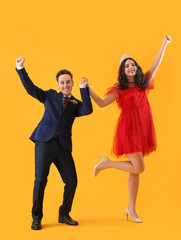 Beautiful couple dressed for prom dancing on yellow background © Pixel-Shot