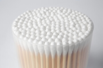 Fototapeta na wymiar Open container with cotton buds on white background, closeup