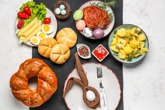 Easter table setting with tasty dishes on light background