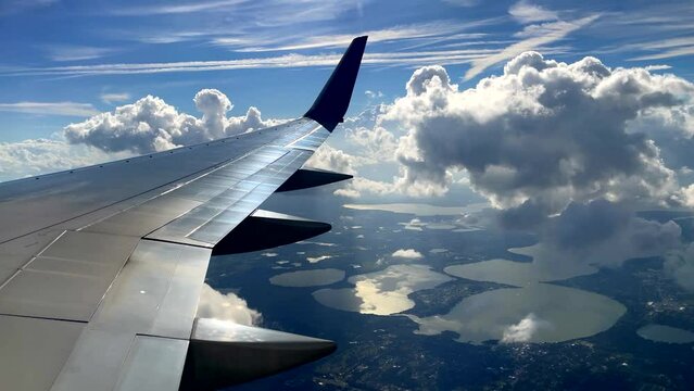 Exceptionally beautiful jet airplane window view of clouds reflected in aircraft wing
