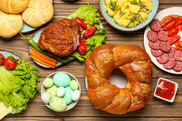 Tasty dishes for Easter dinner on wooden table