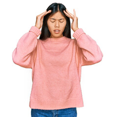 Beautiful young asian woman wearing casual winter sweater with hand on head for pain in head because stress. suffering migraine.