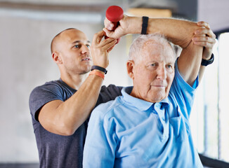 Working his way back to his healthy self. Shot of a physiotherapist helping a senior man with...
