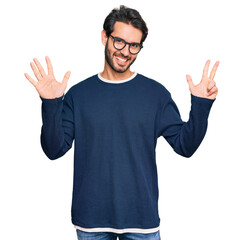 Young hispanic man wearing casual clothes and glasses showing and pointing up with fingers number eight while smiling confident and happy.