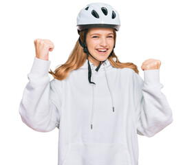 Beautiful young caucasian girl wearing bike helmet screaming proud, celebrating victory and success very excited with raised arms