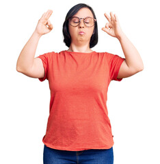 Brunette woman with down syndrome wearing casual clothes and glasses relax and smiling with eyes closed doing meditation gesture with fingers. yoga concept.