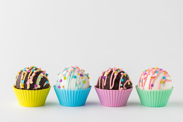 A row of homemade hot chocolate bombs decorated with spring pastel colours.