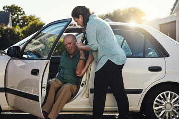Ill be the support you need. Shot of a woman helping her senior father out the car.