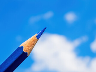 Closeup of blue pencil isolated with sky in background
