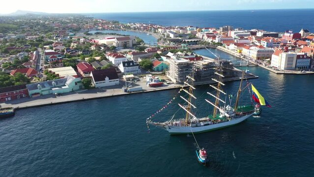 The school ship Gloria, flagship of the Colombian Navy, guided by pilot boats in the port of Willemstad. Cura&ccedil;ao Island.Netherlands Antilles. July 30, 2022