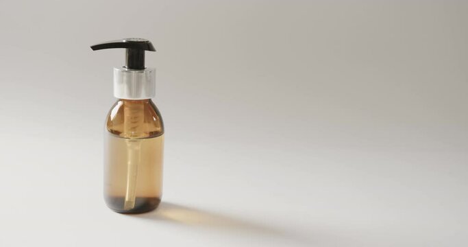Close up of glass bottle with pump with copy space on white background