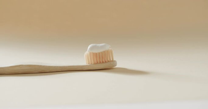 Close up of toothbrush with toothpaste on beige background