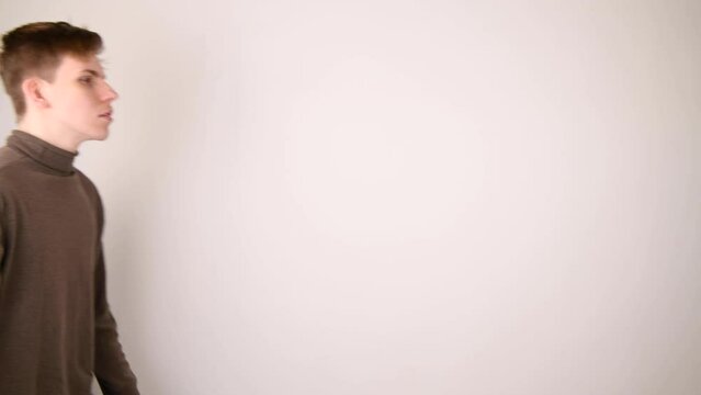 A young man walking by and giving the middle finger and wave goodbye.