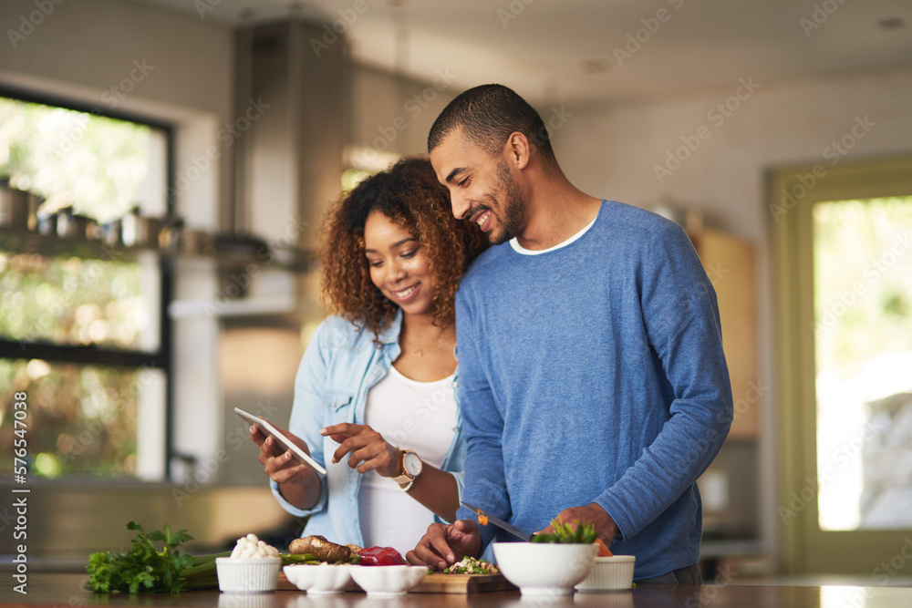 Aufkleber using a step by step online recipe. shot of a happy young couple using a digital tablet while prepar