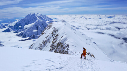 Fototapeta na wymiar A climber enjoying panoramic view on Mt Denali in Alaska, the highest mountain in North America