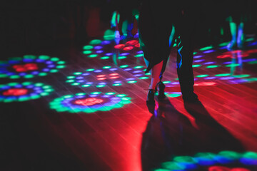 Couples dancing traditional latin argentinian dance milonga in the ballroom, tango salsa bachata kizomba lesson in the red and purple lights, festival, lesson class in dance school class academy