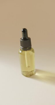 Vertical video of close up of glass bottle with pump and copy space on beige background