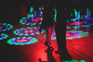 Couples dancing traditional latin argentinian dance milonga in the ballroom, tango salsa bachata kizomba lesson in the red and purple lights, festival, lesson class in dance school class academy