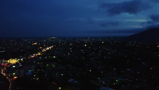 Panoramic aerial view over a illuminated Etoug-ebe neighborhood in the city of Yaounde, dusk in Cameroon