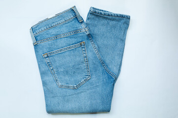 Blue jeans, stack of denim pants, composition, denim texture. top view on white background..