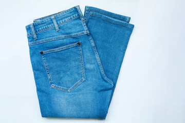 Blue jeans, stack of denim pants, composition, denim texture. top view on white background..