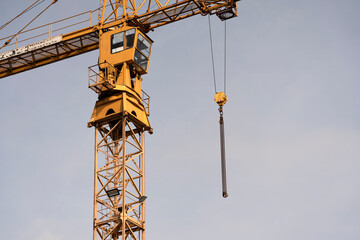 Crane and construction site against the blue sky. Working on large construction sites, and many cranes working in the new construction business.