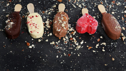 Popsicle ice-cream assortment on dark background.