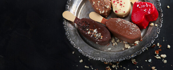 Popsicle ice-cream assortment on dark background.