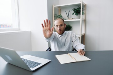 A man in a wheelchair a businessman in the office works, severe fatigue and emotional burnout, anger, integration into society, the concept of work a person with disabilities