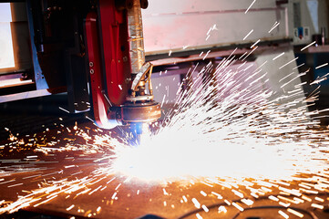Bright flame sparks fly during plasma cutting out of details