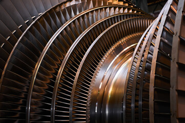 Golden rotor with blade rings of steam turbine in workshop