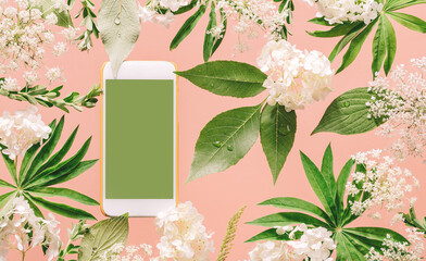 Smartphone mockup with assorted floral and jungle tree green leaves and white flowers on peach pink. Natural friendly plants care or gardening planting mobile app technology