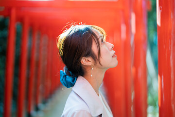赤い鳥居をくぐる女性