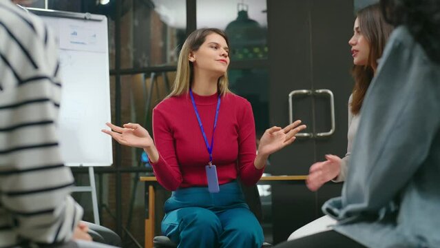The female businesswoman is seen conversing with her team in a contemporary office setting, passionately describing her work with a humorous expression.