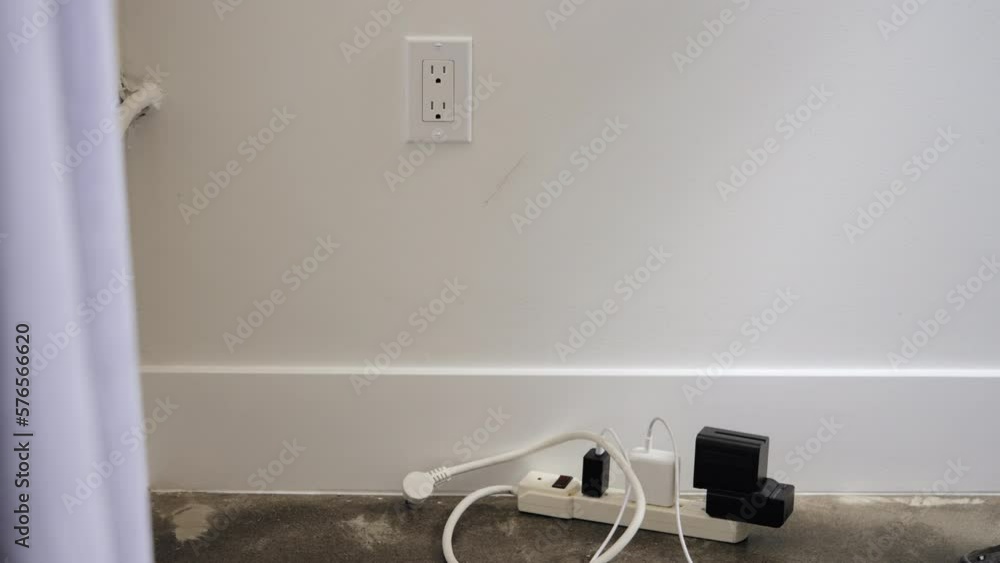 Poster man unplugging the extension cord on wall socket. - close up