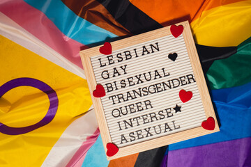 LGBTQIA description frame on Rainbow LGBTQIA flag made from silk material. LESBIAN, GAY, BISEXUAL,...