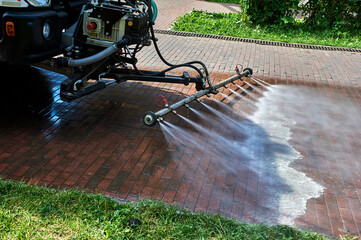 A special machine washes city paths and roads with water