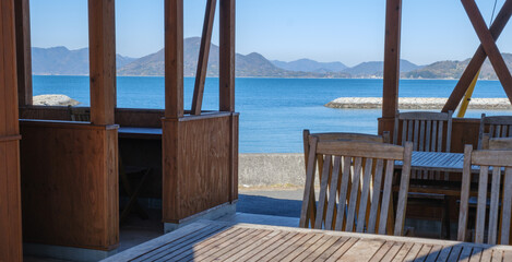 海辺にある食事やリラックスができるテーブルや椅子があるビーチ横の施設