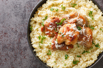 Arborio rice with parmesan and garlic served with fried chicken close-up in a plate on the table. Horizontal top view from above