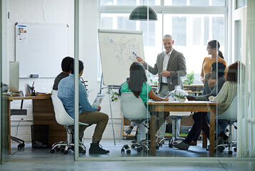 His team is all ears. Shot of a group of coworkers in a boardroom meeting.