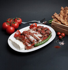 Traditional turkish iskender kebab in copper plate with yogurt, grilled tomatoes and fresh...