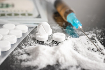 White pills, drugs or medical treatment, cocaine or heroin white powder, syringe with a dose and us...