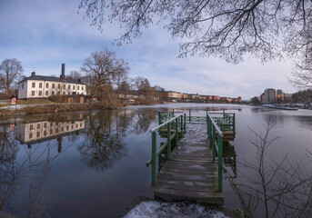 The castle Karlbergs slott at the icy canal Karlbergskanalen, jetty and old apartment buildings on...