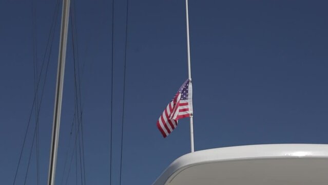 bandera de estados unidos moviendose con la brisa en dia soleado y encima de un yate.