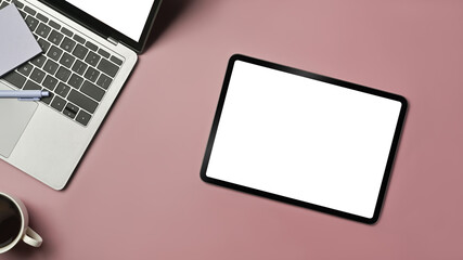 Digital tablet, laptop, coffee cup and sticky notes on pink background. Blank screen for text information or content