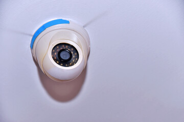 CCTV security camera on white wall background with copy space for text.