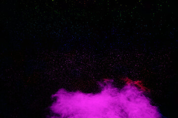 Purple color powder explosion cloud  on black background.Purple dust particles splash.