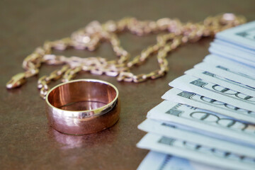 beautiful golden chain and wedding rind with money dollar USA on dark background, pawnshop concept,...