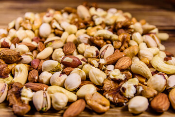 Background of the various nuts (almond, cashew, hazelnut, pistachio, walnut) a wooden table. Vegetarian meal. Healthy eating concept