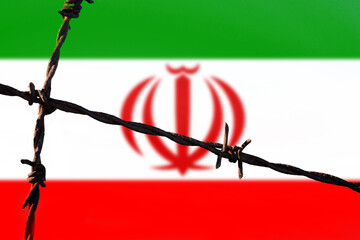 Iran flag behind barbed wire fence. Concept of sanctions, embargo, dictatorship, discrimination and...